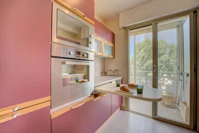 a pink kitchen with a counter and a window at Cannes Californie Beautiful Apt with Sea View in Cannes