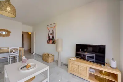 a living room with a tv and a table at Cannes Californie Beautiful Apt with Sea View in Cannes