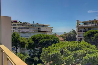 an apartment building on top of a hill with trees at Cannes Californie Beautiful Apt with Sea View in Cannes