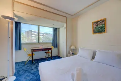 a bedroom with a large white bed and a desk at Croisette, Amazing Beach Views, 1-bed Apt in Cannes