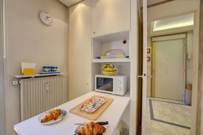 a kitchen with a counter with croissants and a microwave at Croisette, Amazing Beach Views, 1-bed Apt in Cannes