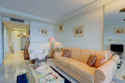 a living room with a couch and a table at Croisette, Amazing Beach Views, 1-bed Apt in Cannes