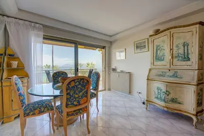 a dining room with a table and chairs and a window at Croisette, Amazing Beach Views, 1-bed Apt in Cannes
