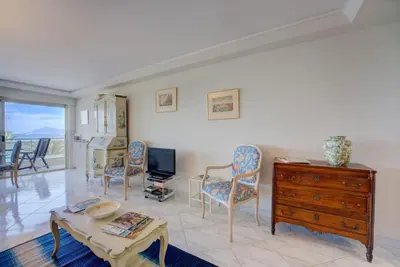 a living room with a table and chairs and a tv at Croisette, Amazing Beach Views, 1-bed Apt in Cannes