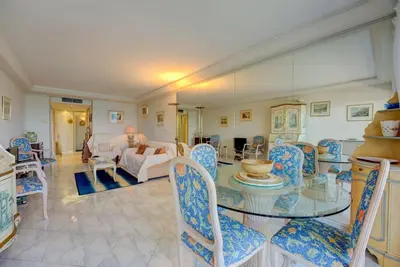 a living room with a glass table and chairs at Croisette, Amazing Beach Views, 1-bed Apt in Cannes
