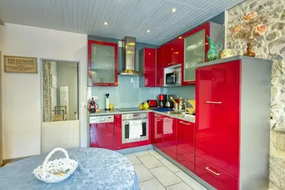 a red kitchen with red cabinets and a table at NEW 2-bed Central Cannes Apt in Cannes