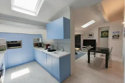 a kitchen with blue cabinets and a dining room at 06DI Cannes Hoche in Cannes