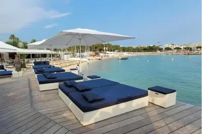 a row of lounge chairs and an umbrella next to a pool at 06DI Cannes Hoche in Cannes