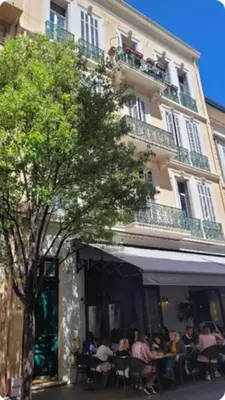a group of people sitting at tables in front of a building at 06DI Cannes Hoche in Cannes
