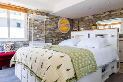 a bedroom with a large bed and a brick wall at Penthouse Duplex with Rooftop Terrace in Cannes