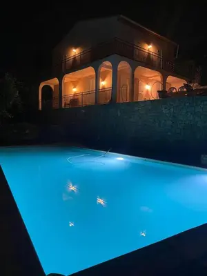a swimming pool with blue lights in front of a house at Villa Riviera in Le Cannet