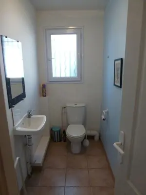 a bathroom with a toilet and a sink and a window at Villa Riviera in Le Cannet