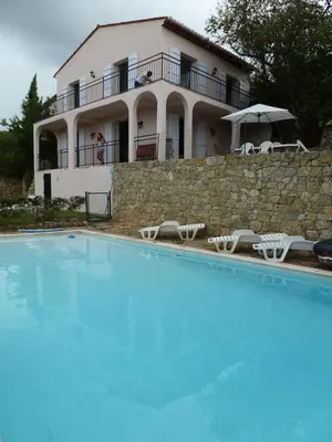 a large swimming pool in front of a house at Villa Riviera in Le Cannet