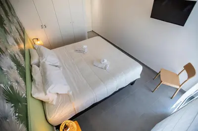 a small bedroom with a bed and a chair at Les Terrasses De Forville by Connexion in Cannes