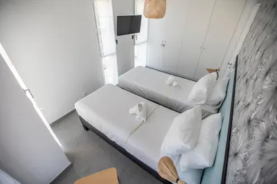 a bedroom with two beds with white sheets and a mirror at Les Terrasses De Forville by Connexion in Cannes