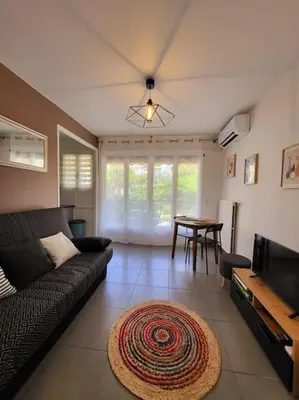 a living room with a couch and a table at Cosy Studio à Cannes 8 min de la Croisette in Cannes