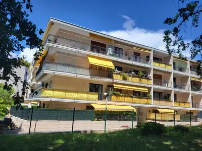 an apartment building with yellow balconies and a fence at Cosy Studio à Cannes 8 min de la Croisette in Cannes