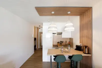 a kitchen with a table and chairs and two lights at Cannes proche Croisette et palais magnifique appartement 4 couchages in Cannes