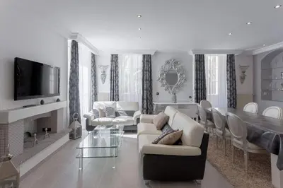 a living room with white furniture and a dining room at Duplex Saint-henry by Halldis in Cannes