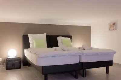 a white bedroom with a white bed with pillows at Duplex Saint-henry by Halldis in Cannes
