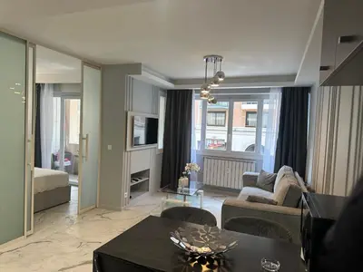 a living room with a couch and a table at Apartment best position croisette martinez ! 150m from the beach completely renovated ! in Cannes