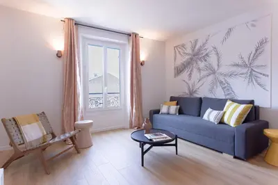 a living room with a blue couch and a window at Duplex Pradignac by Halldis in Cannes