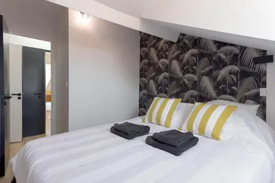 a bedroom with a white bed with two towels on it at Duplex Pradignac by Halldis in Cannes