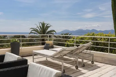 a balcony with chairs and a view of the ocean at Cannes centre - Vue Mer, Piscine, Terrasse in Cannes