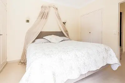 a bedroom with a white bed with a canopy at Cannes centre - Vue Mer, Piscine, Terrasse in Cannes