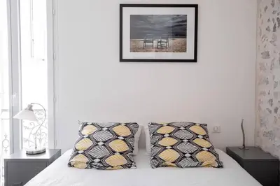 a bedroom with a bed with two pillows and a picture at cannes experience pastour DUPLEX Penthouse Rooftop 4 bed&4bath Sea&Suquet view walking distance palais des congres & beaches in Cannes