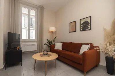 a living room with a brown couch and a table at Splendide et idéalement situé proche du palais. in Cannes