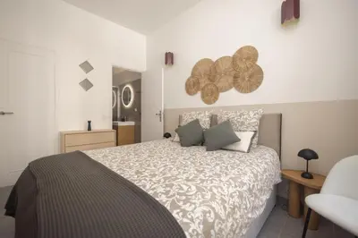 a bedroom with a large bed and a chair at Splendide et idéalement situé proche du palais. in Cannes