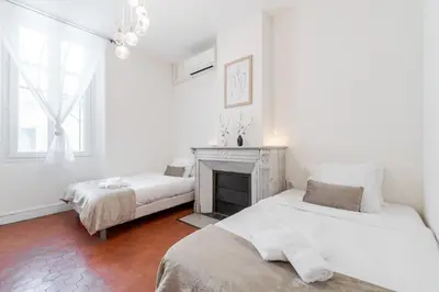 a white room with two beds and a fireplace at BARBARA by Terry's Homes in Cannes