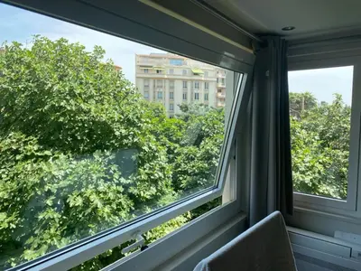a window with a view of trees and a building at Studio mer Croisette in Cannes