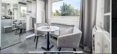 a living room with a table and chairs and a window at Studio mer Croisette in Cannes