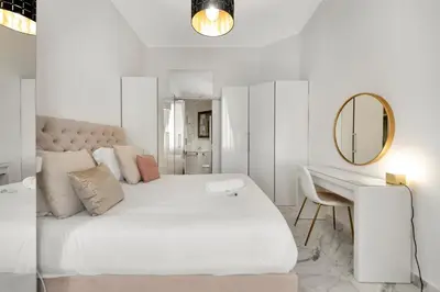 a white bedroom with a large bed and a desk at Le Borniol, splendid 3 bedrooms Appt, Cannes Center in Cannes