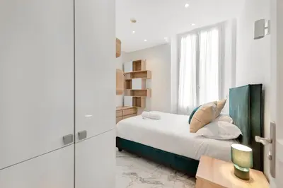 a white bedroom with a bed and a window at Le Borniol, splendid 3 bedrooms Appt, Cannes Center in Cannes
