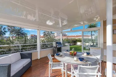 a large living room with a table and chairs at La Palmeraie - Piscine et Toit Terrasse in Cannes