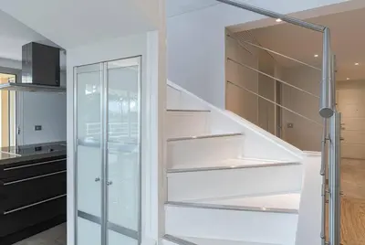 a staircase in a kitchen with white shelves at La Palmeraie - Piscine et Toit Terrasse in Cannes