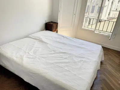 a white bed in a room with a window at 1 bedroom Palais Hoche Cannes 5 mins from the Croisette Cannes Riviera 226 in Cannes