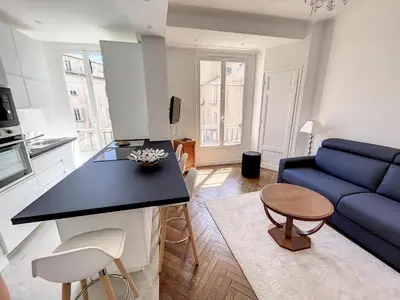 a kitchen and a living room with a blue couch at 1 bedroom Palais Hoche Cannes 5 mins from the Croisette Cannes Riviera 226 in Cannes