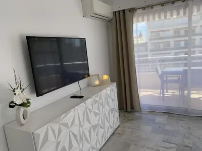 a dining room with a table and chairs and a television at Cannes centre-Palais-200m des plages in Cannes