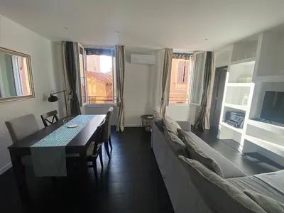 a living room with a dining table and a couch at Agréable T2 rénové, Cannes centre, Suquet, plages in Cannes
