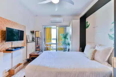 a bedroom with a large bed and a tv at LE FESTIF splendide studio avec loggia au Carré d'Or in Cannes