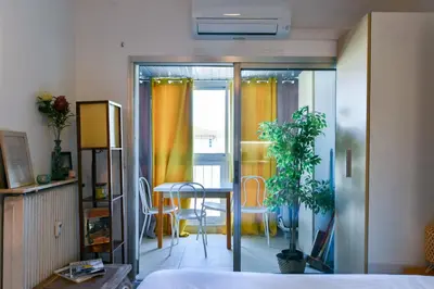 a room with a bed and a table and chairs at LE FESTIF splendide studio avec loggia au Carré d'Or in Cannes
