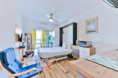 a bedroom with a bed and a desk and a chair at LE FESTIF splendide studio avec loggia au Carré d'Or in Cannes