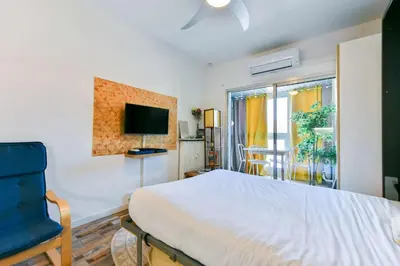 a bedroom with a bed and a tv and a window at LE FESTIF splendide studio avec loggia au Carré d'Or in Cannes