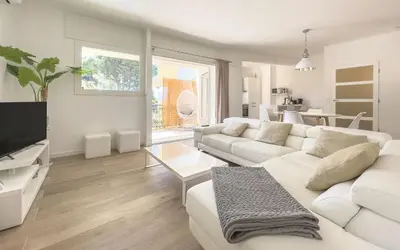 a living room with a white couch and a tv at Le Marilyn by Winsome Destination in Cannes