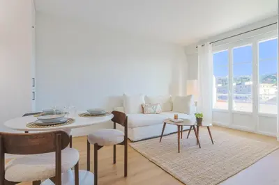 a living room with a white couch and a table at L'impérator by Winsome Destination in Cannes