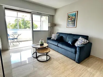 a living room with a blue couch and a table at La douceur de vivre à Cannes in Cannes